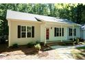 Charming single-story home with a front porch, well-maintained landscaping, and lush trees at 1006 Oxford Ridge Rd, Wake Forest, NC 27587