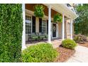 Charming front porch with classic columns, seating, and decorative hanging plants at 109 Lake Point Dr, Clayton, NC 27527