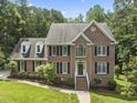 Beautiful brick home with classic shutters, lush landscaping and steps leading to the front door at 111 Canberra Ct, Cary, NC 27513