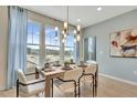 Dining area with a wooden table set for six, a modern light fixture, and large windows at 1190 Alston Landing Way # 2, Cary, NC 27519