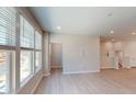 A bright living room features big windows with light gray walls, wood flooring and recessed lights at 1194 Alston Landing Way # 04, Cary, NC 27519