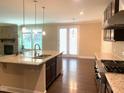 Modern kitchen with granite countertops, stainless steel appliances, and an island sink overlooking the dining area at 1205 Capstone Dr, Durham, NC 27713