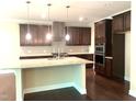 Well-equipped kitchen features stainless steel appliances, granite countertops, an island, and dark wood cabinetry at 1205 Capstone Dr, Durham, NC 27713