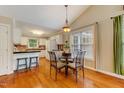 Cozy dining area features hardwood floors, a chandelier, and a view to the kitchen at 1749 Conners Ct, Burlington, NC 27215