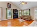 Bright living room with hardwood floors, a fireplace, and large windows with green curtains at 1749 Conners Ct, Burlington, NC 27215