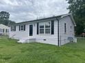 Side view of a light-colored home with black shutters and a chain-link fence at 1851 S Clearview Dr, Henderson, NC 27536