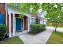 A view of the brick home's covered entryway, front door, and trimmed landscaping at 201 Masterwood Way, Morrisville, NC 27560