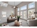 Bright living room with tall windows, a ceiling fan, and neutral decor at 2060 Jersey City Pl, Apex, NC 27523