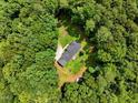 Aerial view of a secluded ranch-style home nestled within a dense green forest, offering privacy at 224 Oakcrest Dr, Wake Forest, NC 27587