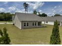 Wide view of the backyard showing manicured lawn, vinyl siding, and neighboring houses at 23 Rolling Banks Dr, Louisburg, NC 27549