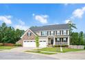 Two-story home with stone accents, a charming front porch with swing, a manicured lawn and a two-car garage at 232 Randleman Ct, Holly Springs, NC 27540