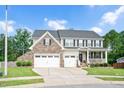 Two-story home with stone accents, a charming front porch with swing, a manicured lawn and a two-car garage at 232 Randleman Ct, Holly Springs, NC 27540