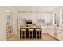 Bright kitchen features white cabinets, stainless steel appliances and a kitchen island with bar stool seating at 2940 C Chapel Hill Road, Durham, NC 27707
