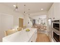 Open kitchen features a white quartz countertop island with bar stools, stainless appliances, and wood flooring at 2940 C Chapel Hill Road, Durham, NC 27707