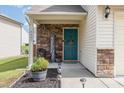 Cozy front porch with stone accents and a welcoming teal door at 4401 Lyman Ave, Raleigh, NC 27616