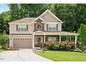 Traditional two-story home with stone accents, attached garage, and meticulously maintained lawn and plantings at 517 Wheddon Cross Way, Wake Forest, NC 27587