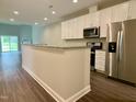 Modern kitchen with white cabinetry, granite countertops, and stainless steel appliances at 656 Barneswyck Dr, Fuquay Varina, NC 27526