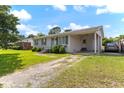 View of single story white brick home featuring a covered carport and driveway at 729 Carolina Dr, Dunn, NC 28334