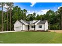 Beautiful new construction home with a two-car garage and manicured lawn in a wooded setting at 80 Birchtop Cir, Zebulon, NC 27597