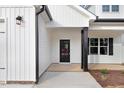 Welcoming front entrance featuring a glass door, black columns, and manicured landscaping at 80 Birchtop Cir, Zebulon, NC 27597