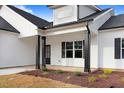 Close-up view of a charming front porch with black columns and dark-framed windows at 80 Birchtop Cir, Zebulon, NC 27597