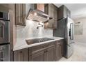 Modern kitchen boasts stainless steel appliances, sleek cabinetry, quartz countertops, and a stylish range hood at 800 Camden Ave, Durham, NC 27701