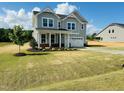 Classic two-story home with a welcoming front porch and beautiful landscaping at 90 Merle Way, Wendell, NC 27591