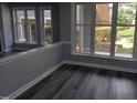 Cozy living room with large windows, gray walls, and stylish wood flooring at 911 Washington St # 102, Raleigh, NC 27605