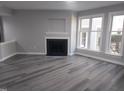 Bright living room showcasing a fireplace, large windows, gray walls, and wood flooring at 911 Washington St # 102, Raleigh, NC 27605