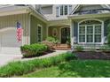 Home's lovely front entrance with a brick pathway and manicured landscaping at 100 Donald Dr, Pittsboro, NC 27312