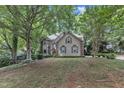 Inviting home with manicured lawn, mature trees, and a quaint, traditional facade at 100 Windvale Ct, Cary, NC 27518