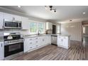 Updated kitchen featuring white cabinets, granite counters, stainless steel appliances, and an island at 1067 Thompson Rd, Four Oaks, NC 27524