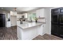 Bright kitchen featuring white cabinets, granite countertops, stainless steel appliances, and a black door at 1067 Thompson Rd, Four Oaks, NC 27524