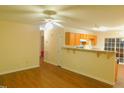 Bright living space featuring hardwood floors, ceiling fan, and breakfast bar to kitchen at 1098 Blackstone Dr, Creedmoor, NC 27522