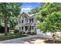 Beautifully landscaped home featuring a lush lawn, mature trees, and a two-car garage at 115 E Seve Ct, Morrisville, NC 27560