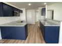 Modern kitchen features granite countertops, stainless steel appliances, and navy blue cabinets at 140 Oakfield Trace Dr, Four Oaks, NC 27524