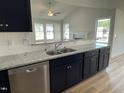 Bright kitchen showcasing granite countertops, navy blue cabinets, and stainless steel appliances at 140 Oakfield Trace Dr, Four Oaks, NC 27524