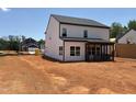 Back of a two-story house featuring large windows and a covered back porch overlooking the yard at 1413 Malcus Ct # 61, Fuquay Varina, NC 27526