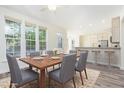 Bright dining area with a wooden table, six chairs, and a view of the backyard next to the kitchen at 1613 Patterson Grove Rd, Apex, NC 27502