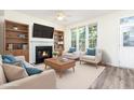 Comfortable living room with a fireplace, built-in bookshelves, and abundant natural light from large windows at 1613 Patterson Grove Rd, Apex, NC 27502