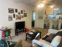 Inviting living room featuring neutral carpeting, ceiling fan, and access to kitchen and bedroom at 2000 University Woods Rd # 203, Raleigh, NC 27603