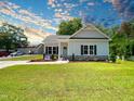 Inviting single story home with manicured lawn, charming shutters, and stone accents at 202 S Pearl St, Princeton, NC 27569