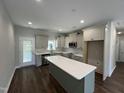 Bright kitchen with stainless steel appliances, quartz countertops, a center island and pendant lighting at 202 S Pearl St, Princeton, NC 27569
