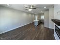 Spacious living room featuring hardwood floors, a ceiling fan, and an open layout with kitchen views at 202 S Pearl St, Princeton, NC 27569