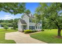 A charming home featuring a long driveway and lush, green landscaping at 209 Bradley Dr, Benson, NC 27504