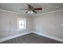 A bright bedroom features neutral walls and flooring with a ceiling fan and light fixture at 306 W Main St, Pine Level, NC 27568