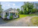 Quaint cottage exterior showcasing a cozy front porch and gravel driveway at 306 W Main St, Pine Level, NC 27568