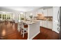 Open concept kitchen with island, granite countertops, stainless appliances, and white cabinetry at 3661 Manifest Pl, Cary, NC 27519