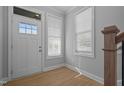 Bright foyer with wood-look floors, white door with sidelight, and natural light from windows at 701 Jamescroft Way, Rolesville, NC 27571