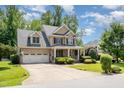 Inviting brick home with well-manicured lawn, two-car garage, and covered front porch at 7336 Capulin Crest Dr, Apex, NC 27539